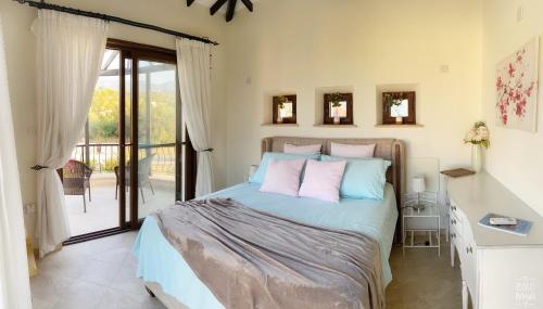 ein Schlafzimmer mit einem Bett und einem Balkon in der Unterkunft Sunset Serenity room with ensuite No1 The Lanterns in Kyrenia