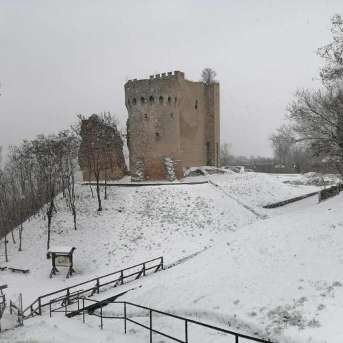 a castle in a snow covered park with a bench at Holiday Home Paunovaca in Erdut