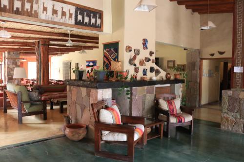 蒂爾卡拉的住宿－Hotel Punta Corral，客厅配有椅子和壁炉
