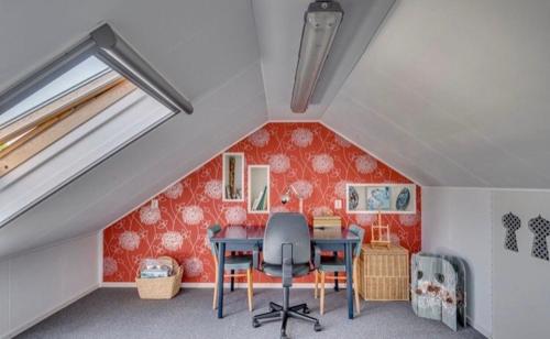 um quarto com uma mesa e cadeiras num sótão em Huis Kleur em Grubbenvorst