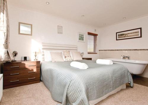 1 dormitorio con cama y bañera en Herons Brook Retreat Lodges, en Narberth