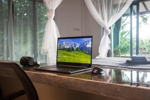 un ordinateur portable assis sur un bureau avec une fenêtre dans l'établissement Deep Dream Chalet, à Hinkong