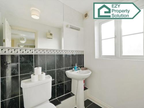 a bathroom with a white toilet and a sink at Stylish 2 bed Apt - Free Parking in Thamesmead