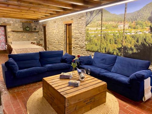 Sala de estar con sofás azules y mesa de centro en CAMPALANS Hotel Rural Bungalows Mobilhomes, en Borredá