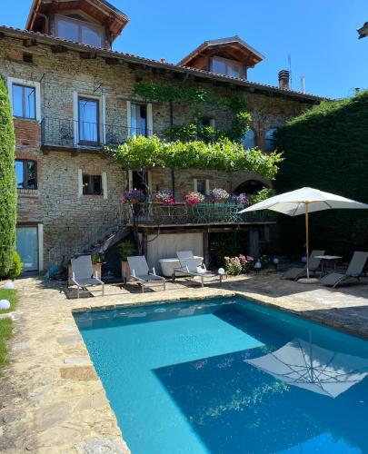 a house with a swimming pool in front of a building at Maison Otto in Bossolasco