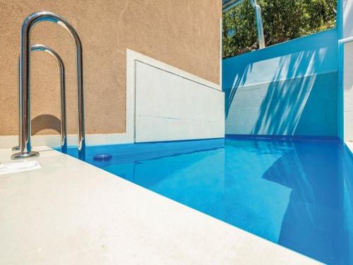a swimming pool with blue floors and metal faucets at Apartments Villa Kim in Jablanac