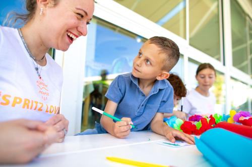 a woman and a young boy sitting at a table at Hotel Albatros in Rimini