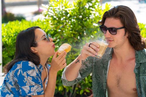 a man and a woman eating food and drinking beer at Hotel Albatros in Rimini