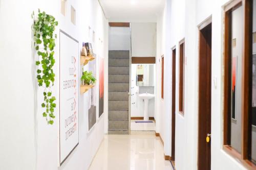 a hallway with plants on the walls and a sink at ROOM Ijen Hostel in Banyuwangi