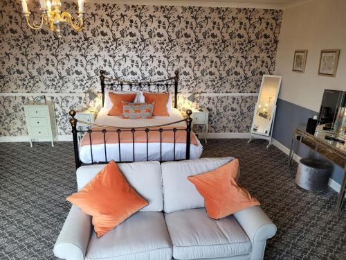 a bedroom with a bed and a couch in a room at Loch Melfort Hotel in Ardfern