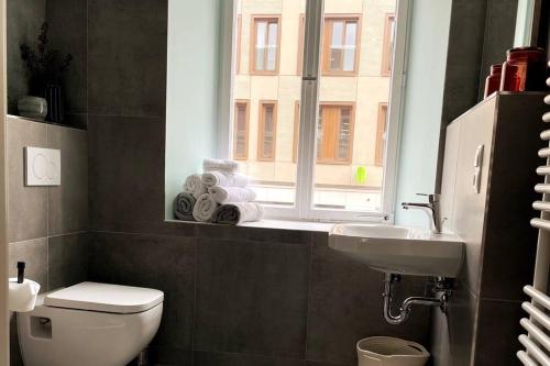 a bathroom with a toilet and a sink and a window at Penthouse Wohnung in 1A City-Lage in Bamberg in Bamberg