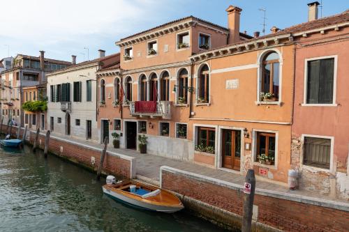 a canal with buildings and a boat in the water at Excess Venice Boutique Hotel & Private Spa - Adults Only in Venice