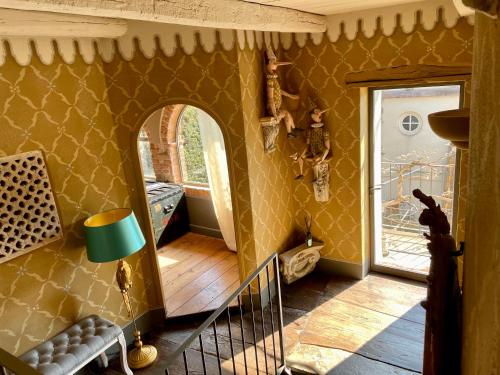 a living room with yellow walls and a wooden floor at Maison Otto in Bossolasco