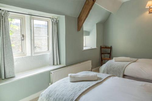 1 dormitorio con 2 camas y ventana en Charming Country Cottage Near Nailsworth en Box