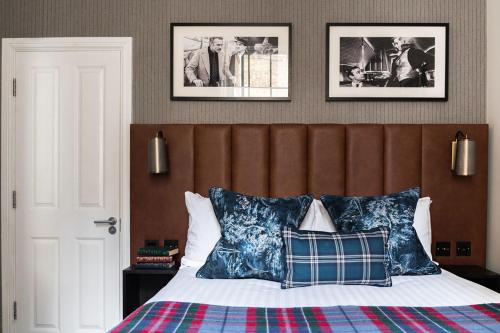 a bedroom with a bed with two pictures on the wall at The Tophams Hotel in London