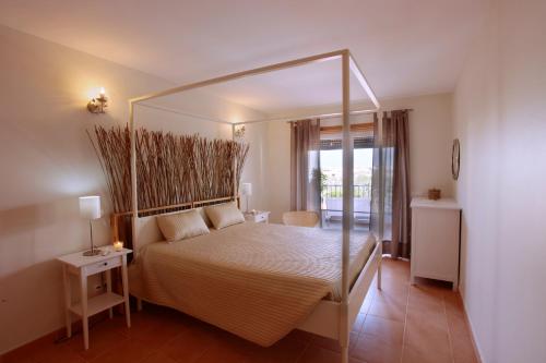 1 dormitorio con cama con dosel en una habitación en Apartamentos Villa T2 Vila Sagres, en Sagres