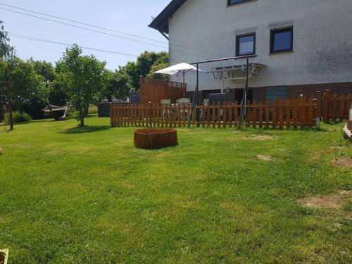 a yard with a wooden fence and a house at Ferienwohnung BeLa, Nähe Nürburgring in Luxem