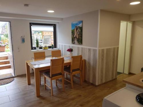 a dining room with a wooden table and chairs at Ferienwohnung BeLa, Nähe Nürburgring in Luxem