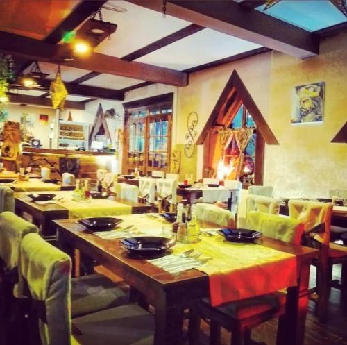 a dining room with tables and chairs with yellow table cloth at Kraljevsko selo Kotromanićevo in Doboj