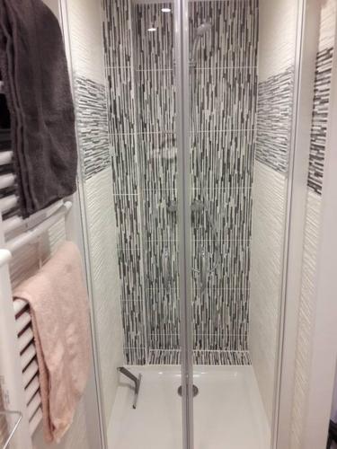 une douche avec une porte vitrée dans une salle de bain dans l'établissement Appartement familiale jusqu'à 4 personnes 5mn à pied du centre, à Honfleur