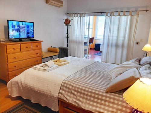 a bedroom with a bed and a tv on a dresser at Cascais - Localização AC Parking Lift in Cascais