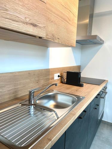una cucina con lavandino e piano di lavoro in legno di Ciney - Le nid du Clocher a Ciney