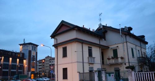 a building on a city street with a clock tower at Appartamenti Leonardo in Rho