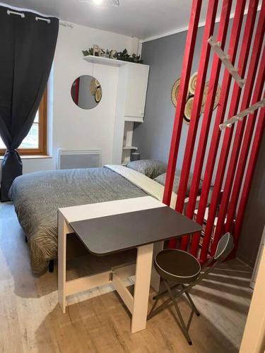 een slaapkamer met een bed, een tafel en een stoel bij Appart hôtel Toucy in Toucy