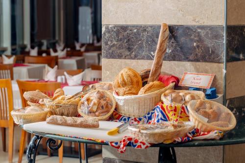 stół z koszami chleba i innych żywności na nim w obiekcie Coral Sea Beach and Aqua Park w mieście Ajn Suchna