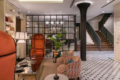 a living room with two chairs and a staircase at Vincci Molviedro in Seville