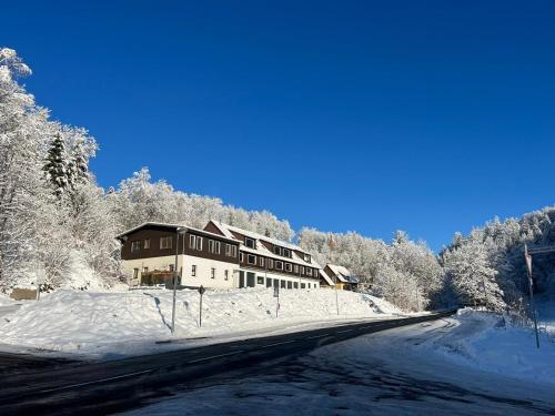a building on a snowy road with snow covered trees at Breeman im Harz in Sankt Andreasberg