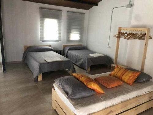 Villafranca de los CaballerosにあるAlojamiento El Pez Casa con piscina climatizadaのベッド2台、ソファ(枕付)が備わる客室です。