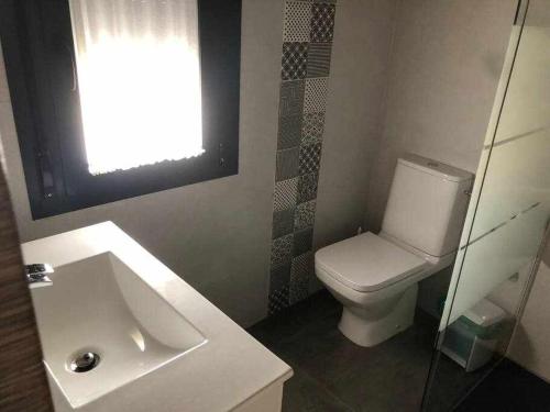 Villafranca de los CaballerosにあるAlojamiento El Pez Casa con piscina climatizadaのバスルーム(トイレ、洗面台付)、窓が備わります。