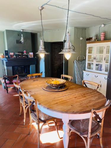 a dining room with a wooden table and chairs at Maison Otto in Bossolasco