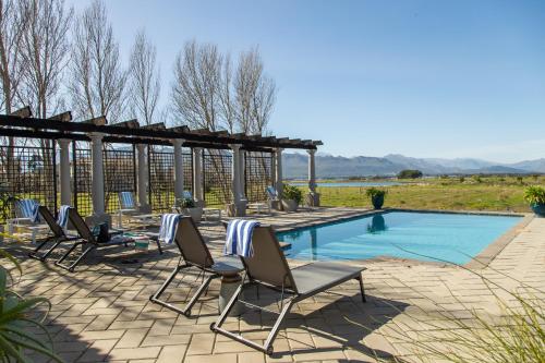 un gruppo di sedie a sdraio accanto alla piscina di Santé Wellness Retreat & Spa a Paarl