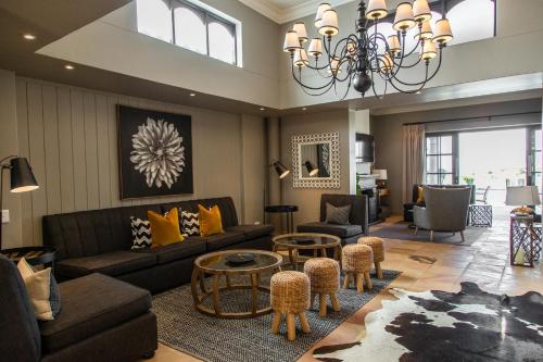 a living room with a couch and chairs and a chandelier at Santé Wellness Retreat & Spa in Paarl