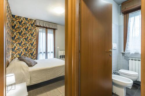 een slaapkamer met een bed, een toilet en een wastafel bij Residenza Il Fiore in Bergamo