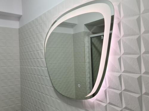 a bathroom with a mirror on a wall at Global Residence in Bucharest
