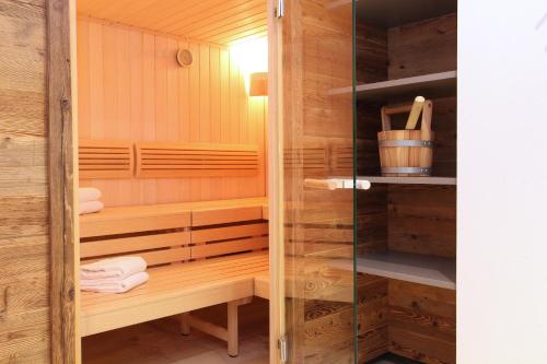 a sauna with wooden walls and a glass door at AvenidA Mountain Resort by Alpin Rentals - incl Summercard in Kaprun