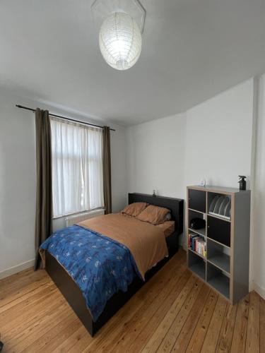 1 dormitorio con cama y ventana grande en L Escapade Urbaine, en Bruselas