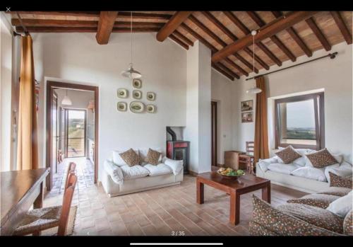 a living room with white couches and a table at Casettone di Torre Venturini in Civitella dʼAgliano