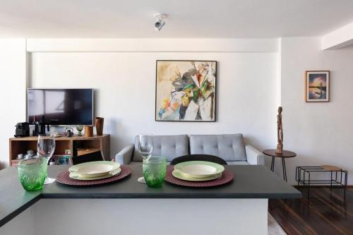 una sala de estar con una mesa con platos y vasos. en Loft do Serjoca, en São Paulo