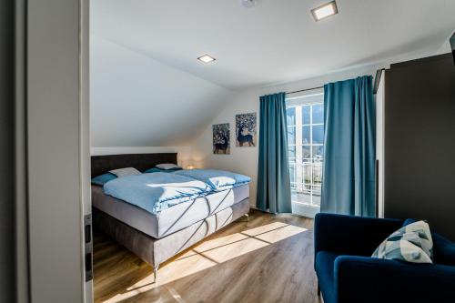 ein Schlafzimmer mit einem Bett, einem Sofa und einem Fenster in der Unterkunft Hotel am See in Kreuzau