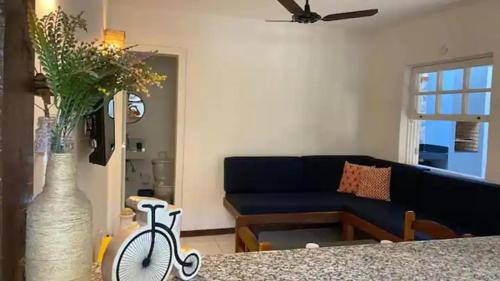 a living room with a blue couch and a vase with a bike at Casa Búzios Villas Centro Búzios in Búzios