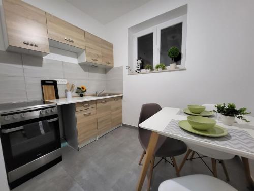 a kitchen with a table and a stove top oven at Cozy apartment with balcony 10 min from the beach in Rijeka