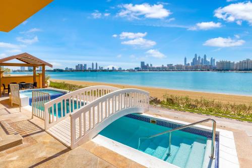 a swimming pool with a bridge over a body of water at FAM Living - Palm Jumeirah - Beach Villas with Private Pool in Dubai