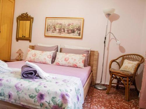 a bedroom with a bed and a lamp and a chair at Maria's guesthouse Volos in Volos