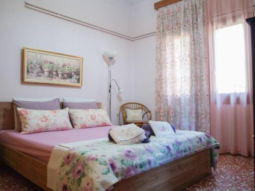 a bedroom with a bed and a window with curtains at Maria's guesthouse Volos in Volos