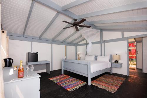 um quarto com uma cama e uma ventoinha de tecto em Conch Beach Cabins 