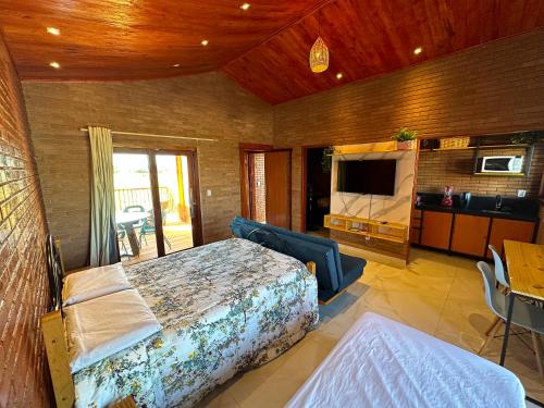a bedroom with a bed and a television in a room at Bem te quero Pipa- apt superior in Pipa